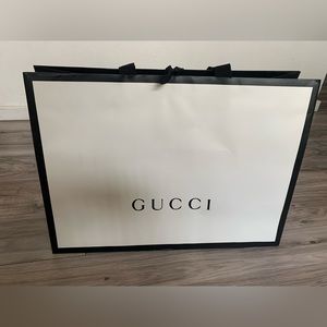 Gucci store gift bag, black and white with ribbon tie handles.